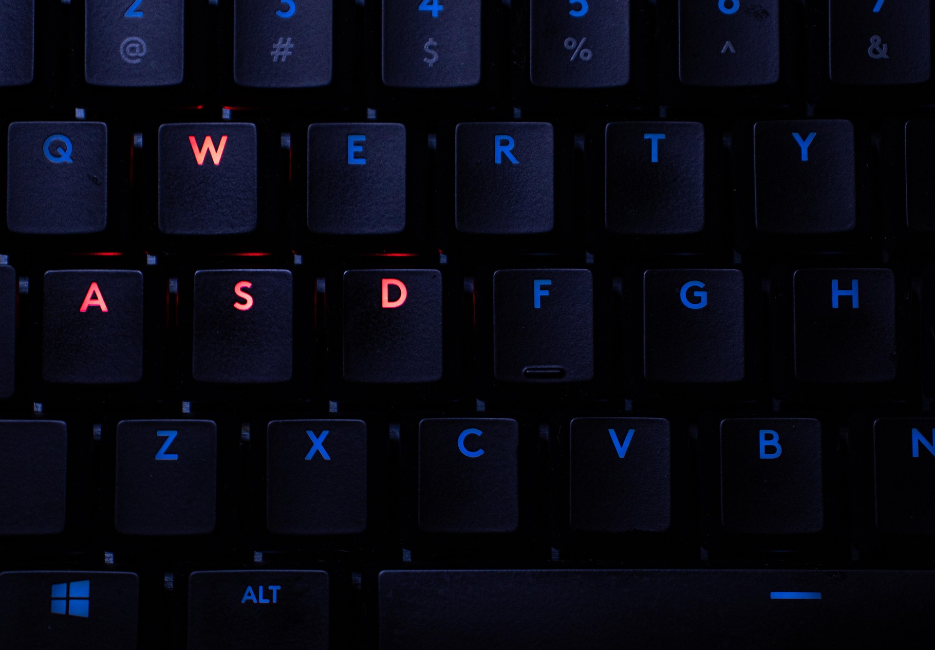 赤く光るWASDキーが目立つゲーミングキーボードのクローズアップ